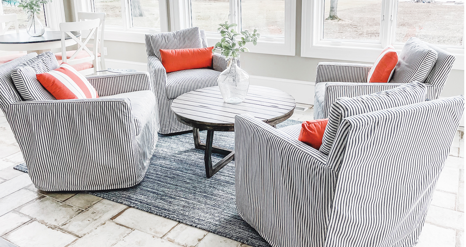 Four comfortable white and navy striped chairs around a circular coffee table.